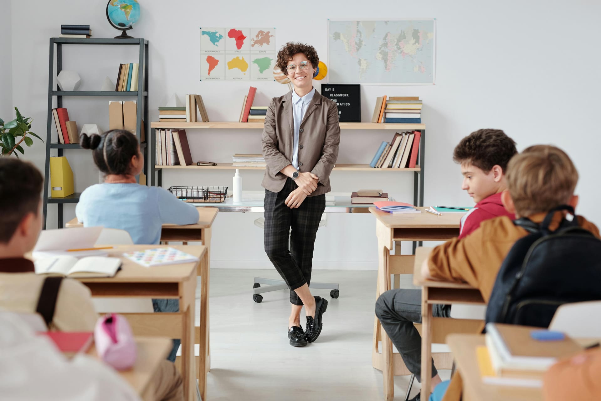 Tutor guiding international school students in a classroom